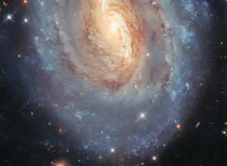 Hubble registra uma galáxia que brilha em azul e dourado