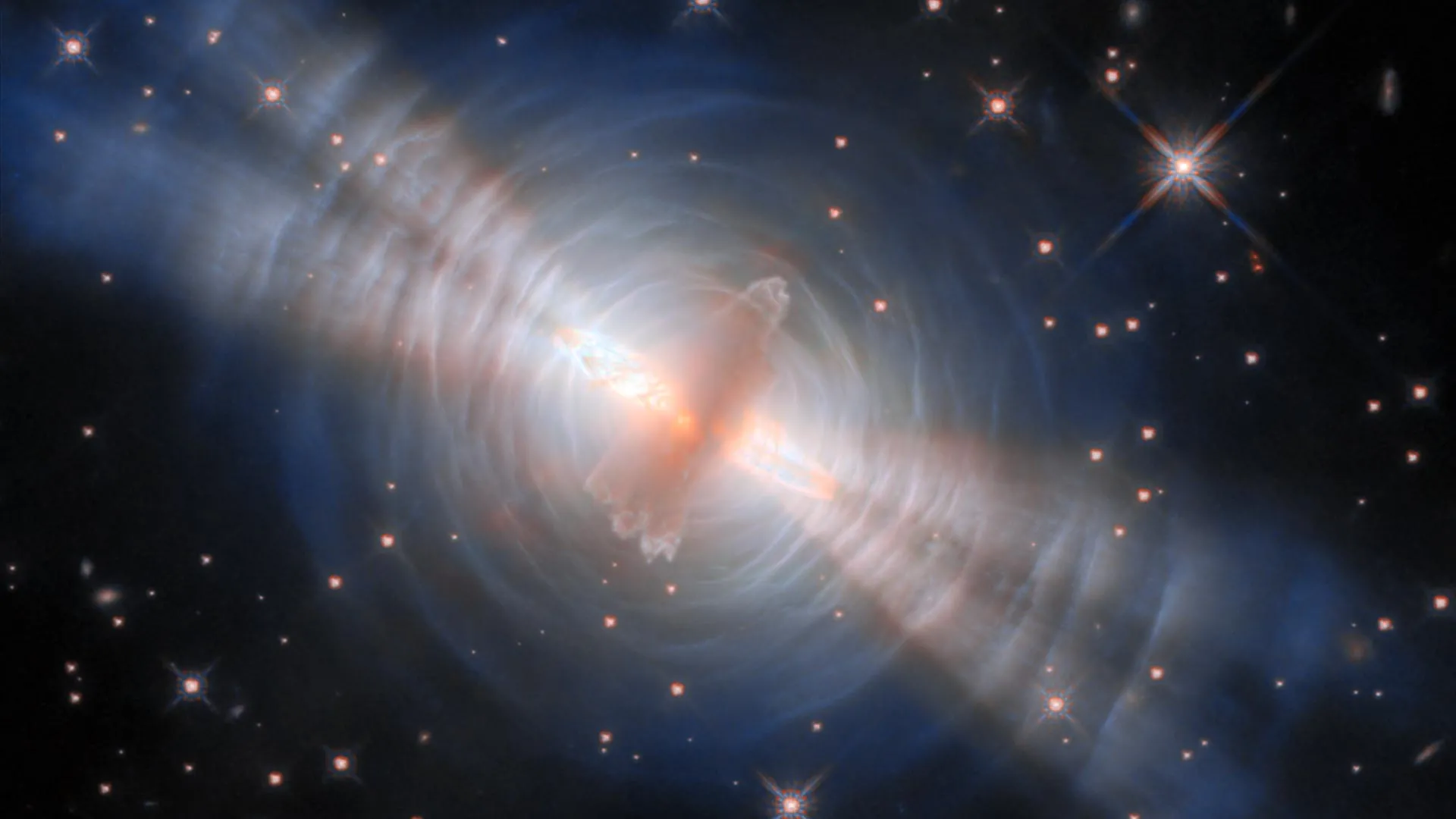 Rajadas de duplas luzes emanam de uma estrela oculta em deslumbrante imagem do Telescópio Espacial Hubble